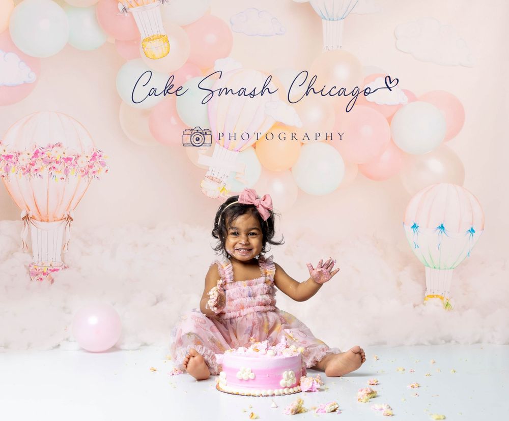 Baby during hot air balloon-themed cake smash in Glenview IL studio featuring pastel balloons, dreamy decor, and matching cake.