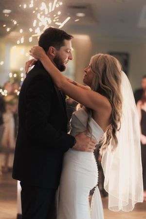 Romantic first dance moment with sparklers creating magical light effects in background.