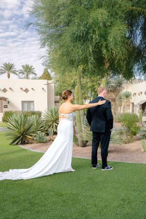 Wedding couple sharing a first look moment in a desert garden setting with palm trees.