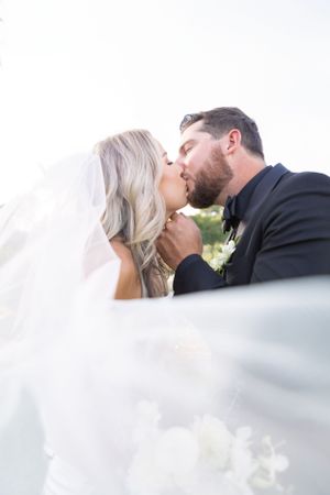 Romantic wedding portrait with flowing veil and soft natural lighting.