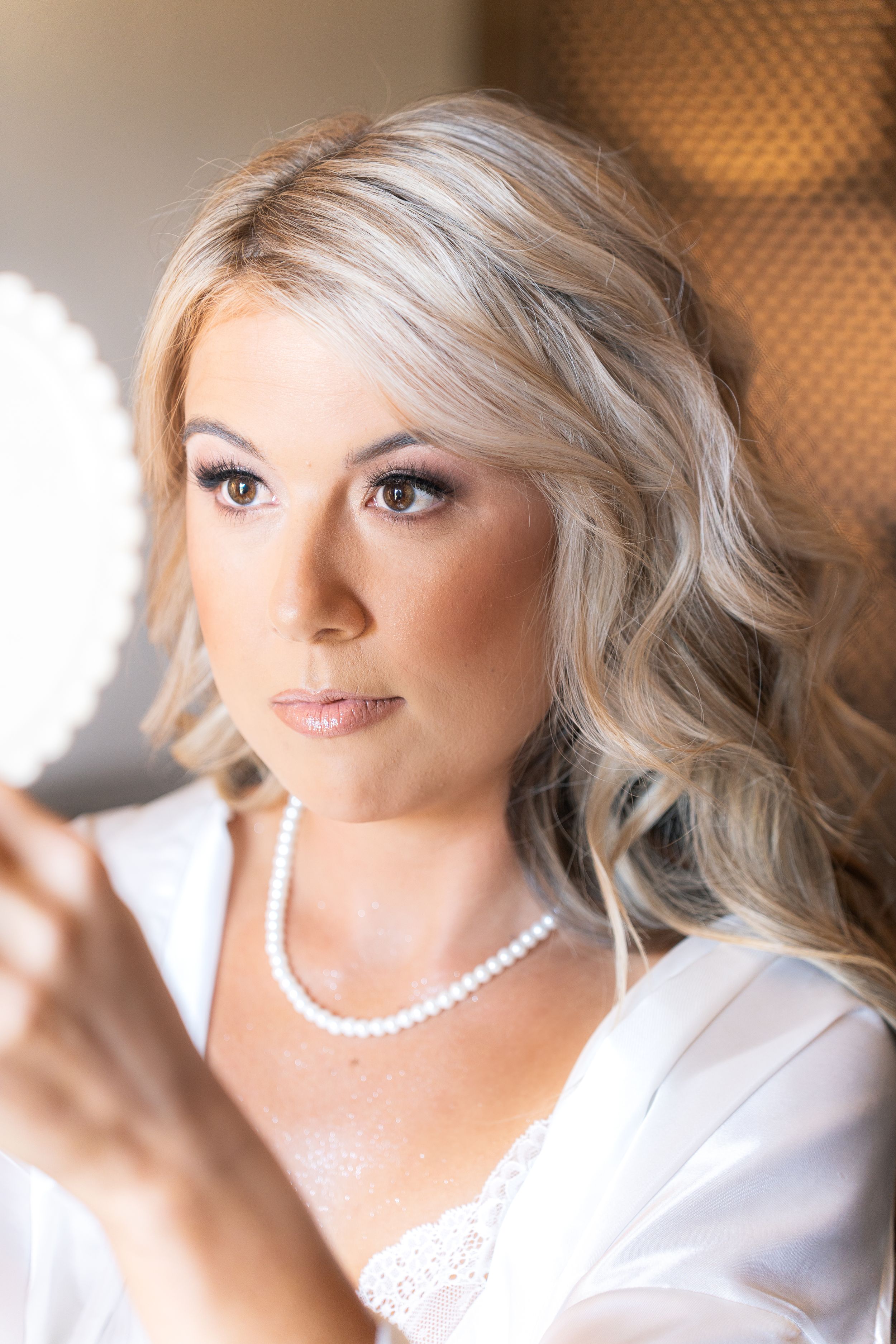 Close up portrait of bride wearing pearl necklace and soft makeup.