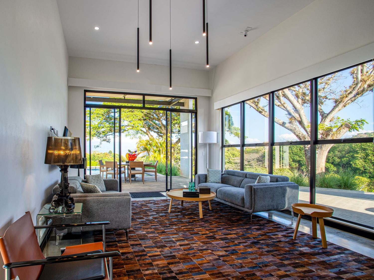 Elegant living room with large windows, natural light, and stylish furniture in a contemporary Costa Rica home