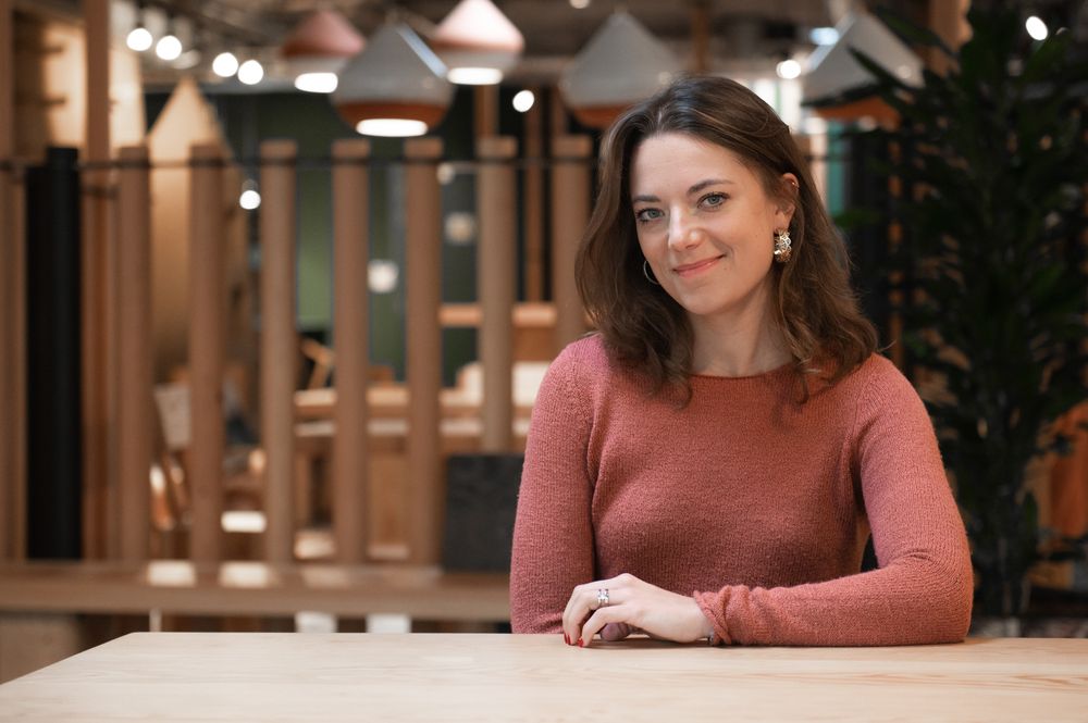 Person working at desk in modern office space with warm lighting.