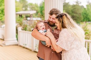 Intimate family portrait session captured on an elegant white columned porch.