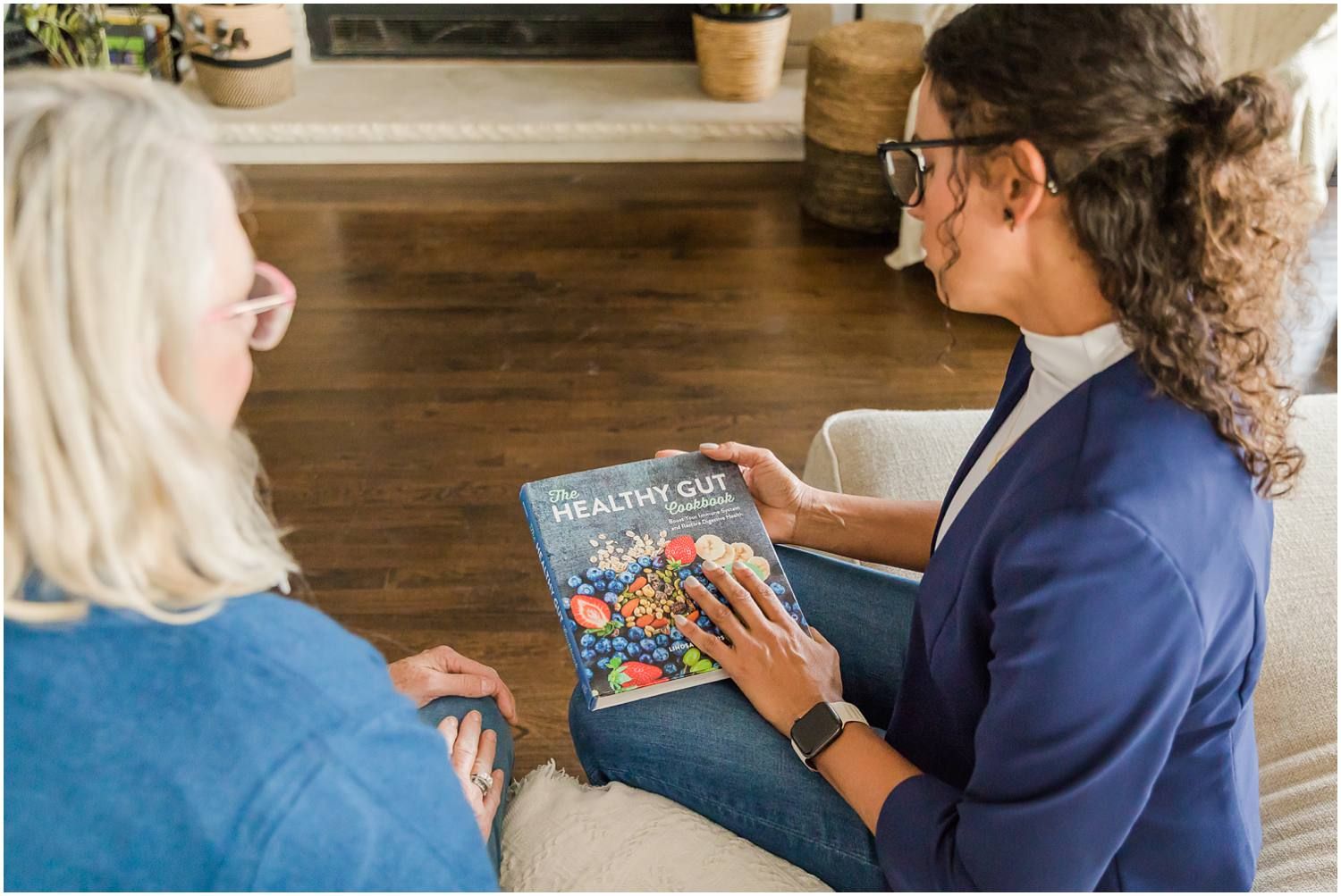 Woman talking with female client in living area about health book