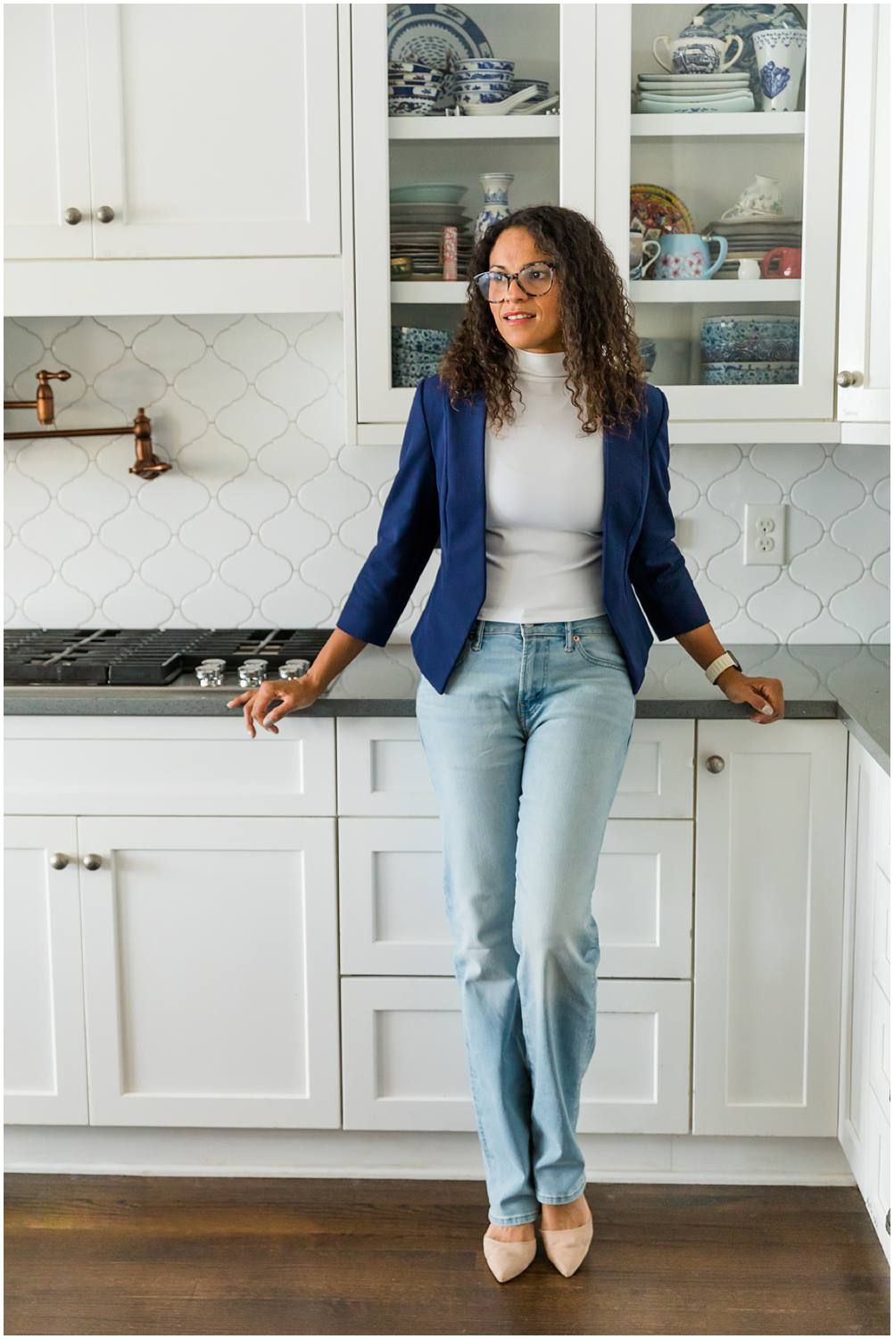 Woman posing in kitchen with hands on counter