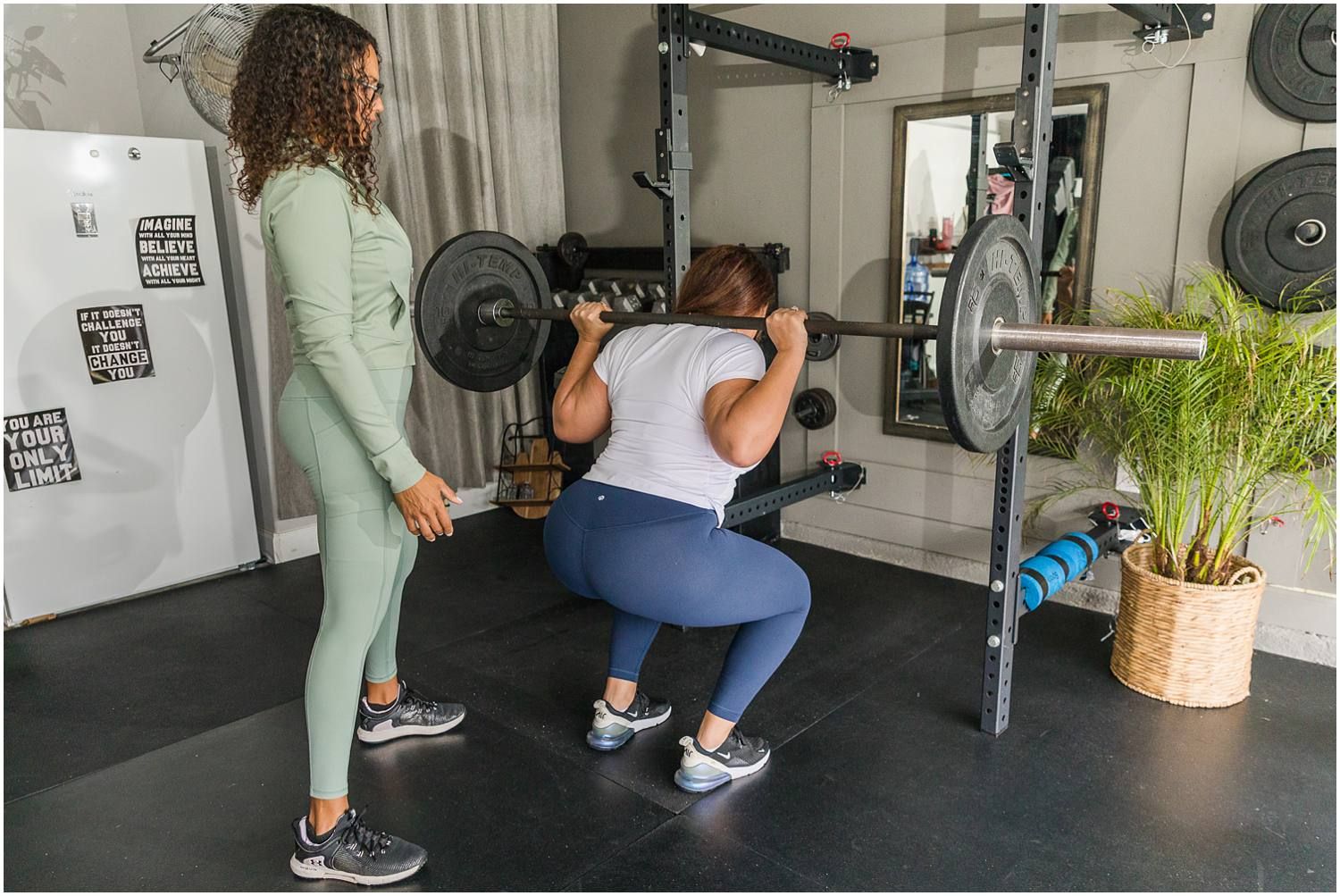 Fitness instructor helping female client with weights