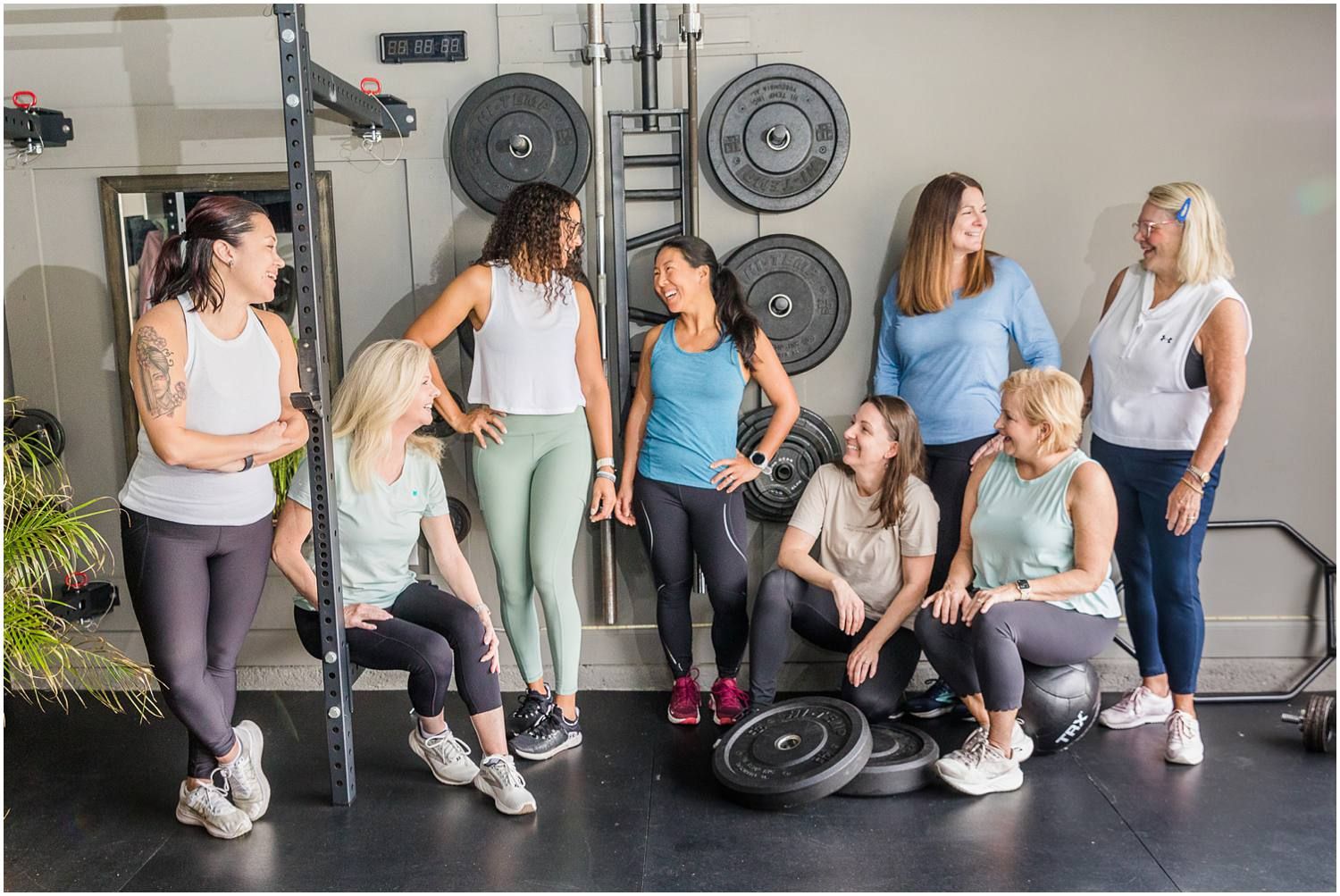 Group of women laughing and posing in gym setting