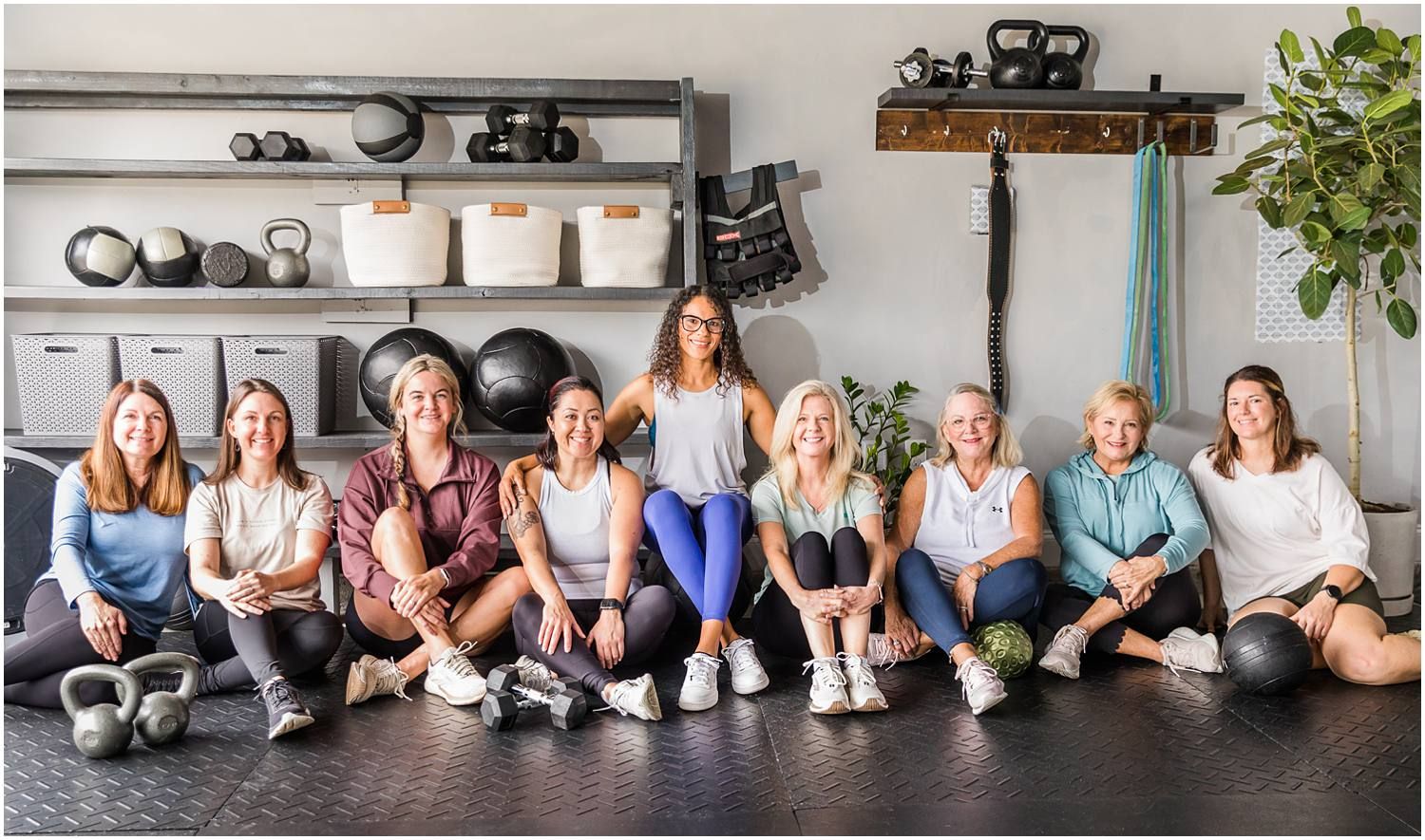 Fitness instructor posing with female clients in gym setting