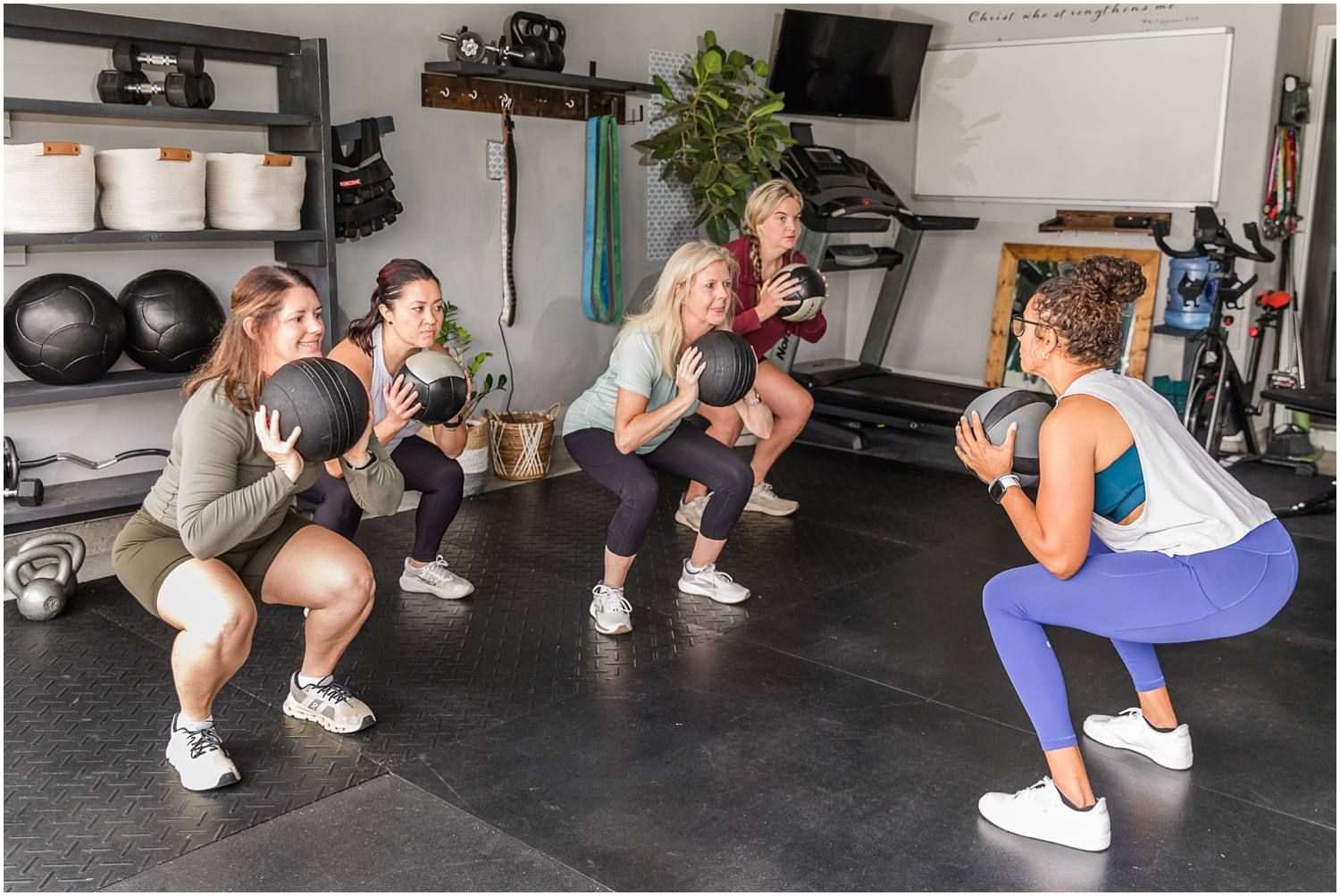 Fitness instructor teaching female clients kettle bell squat