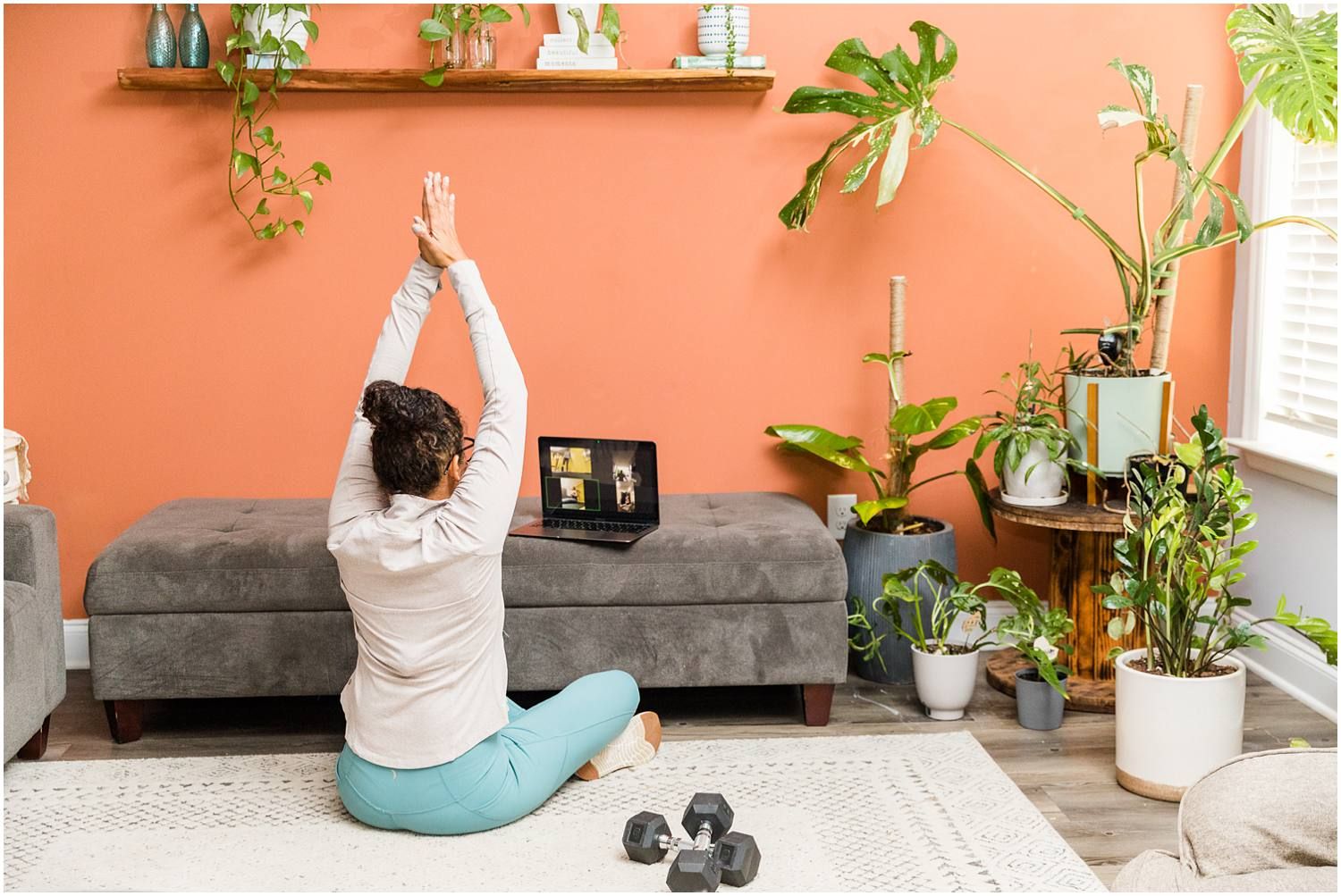 Fitness instructor demonstrating stretching on zoom call in living room