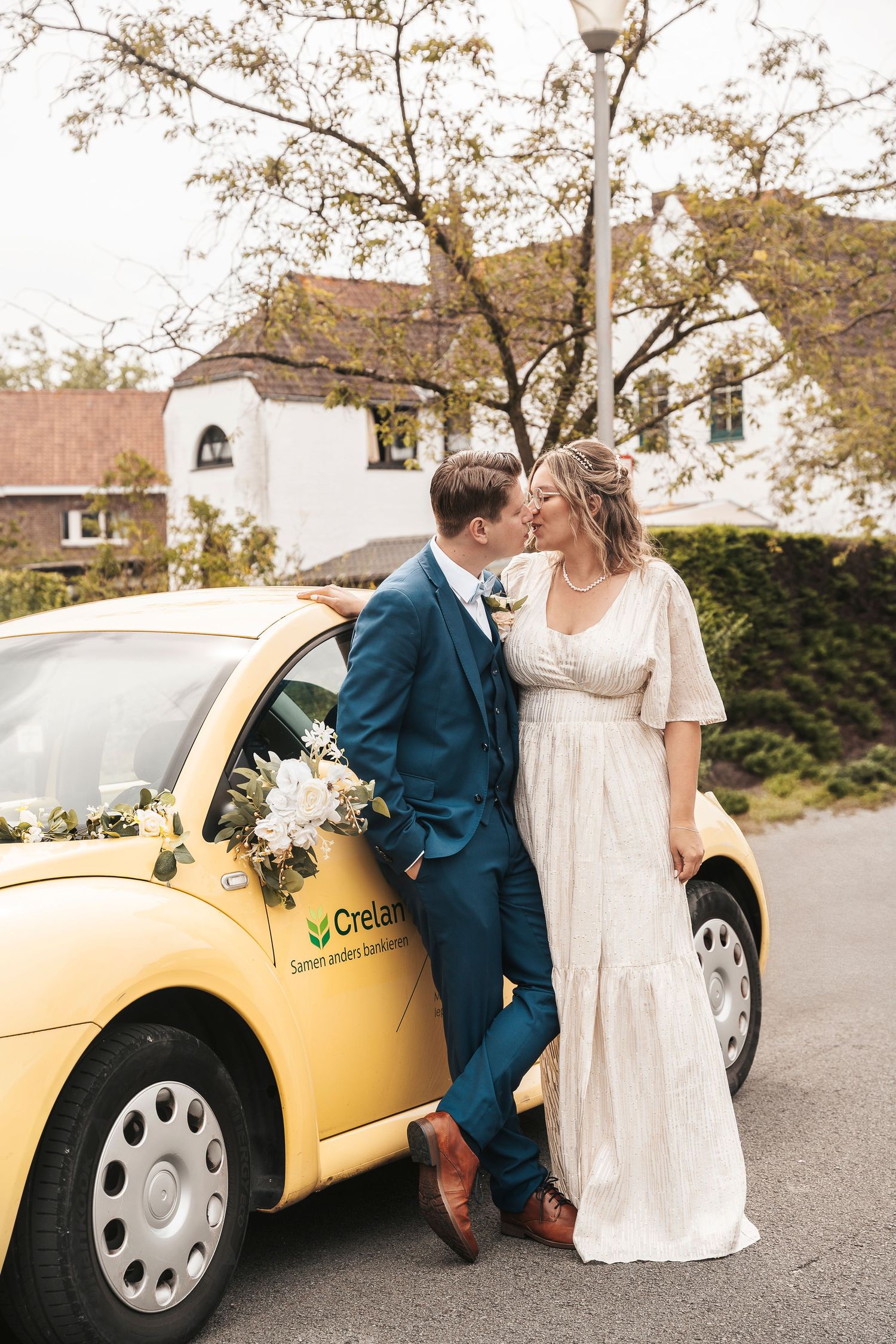 A romantic wedding portrait against a yellow taxi with autumn trees in the background.