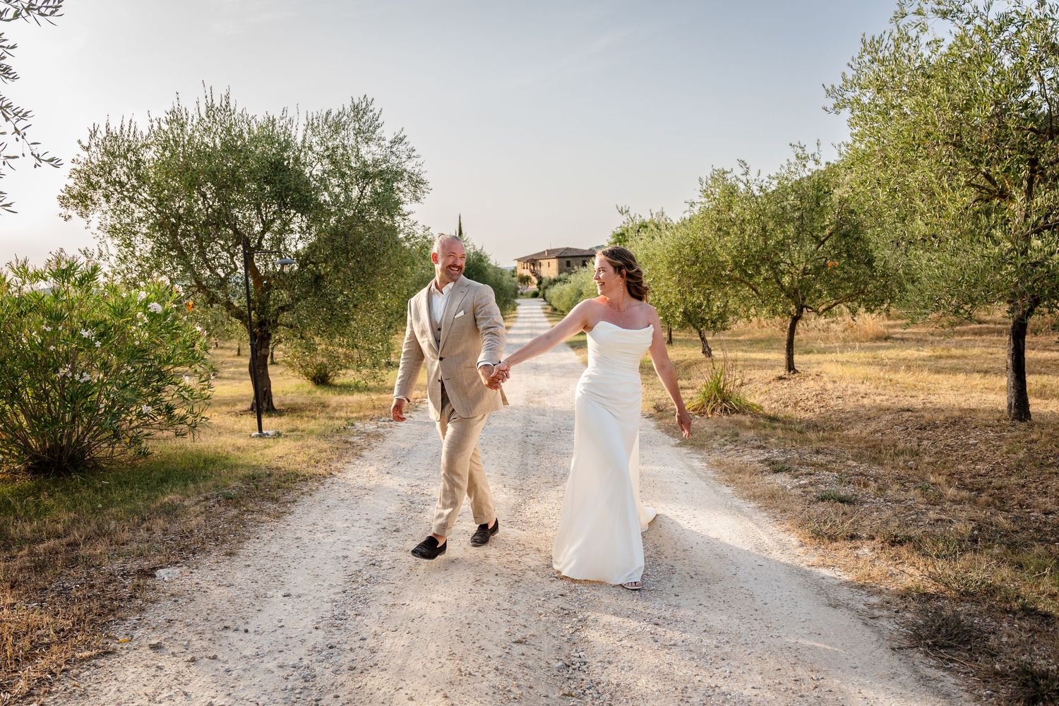 Elegant outdoor wedding portrait with white bouquet and flowing veil.