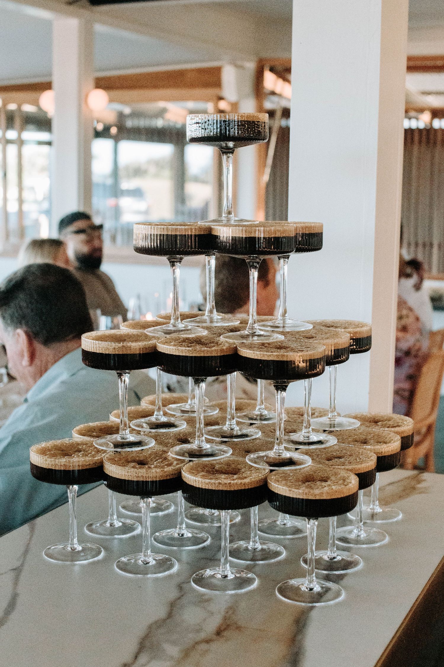 A tiered display of champagne glasses arranged at a wedding reception venue.