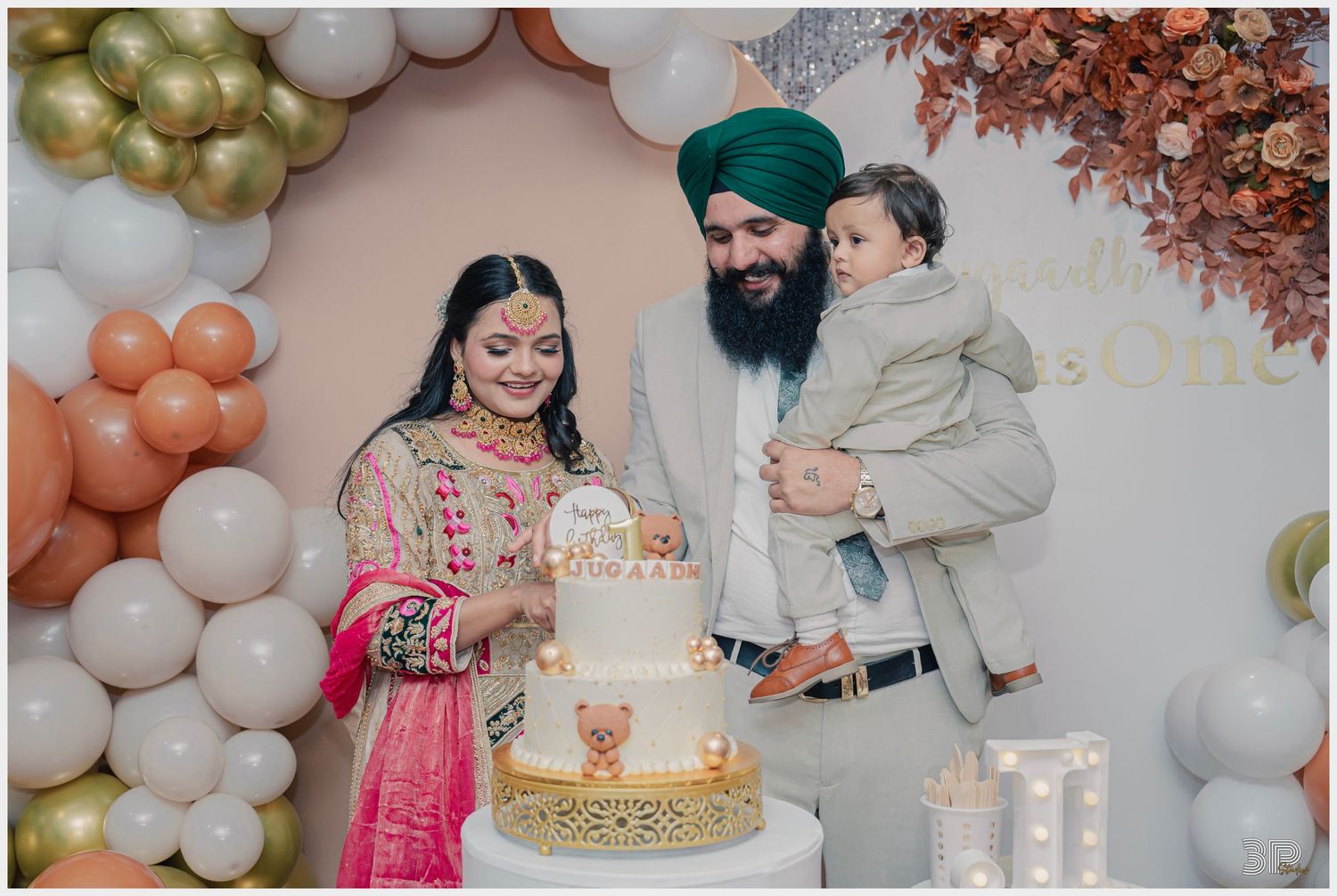 Family of three, including 1 child, smiling together in a relaxed indoor setting during a family photoshoot.