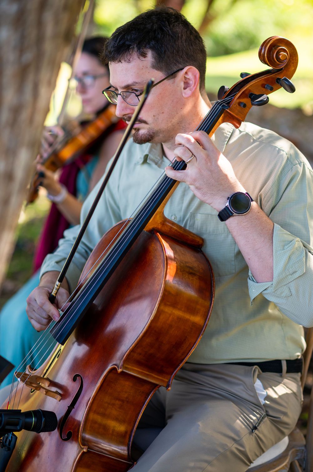 Musicians playing string instruments during an outdoor event.