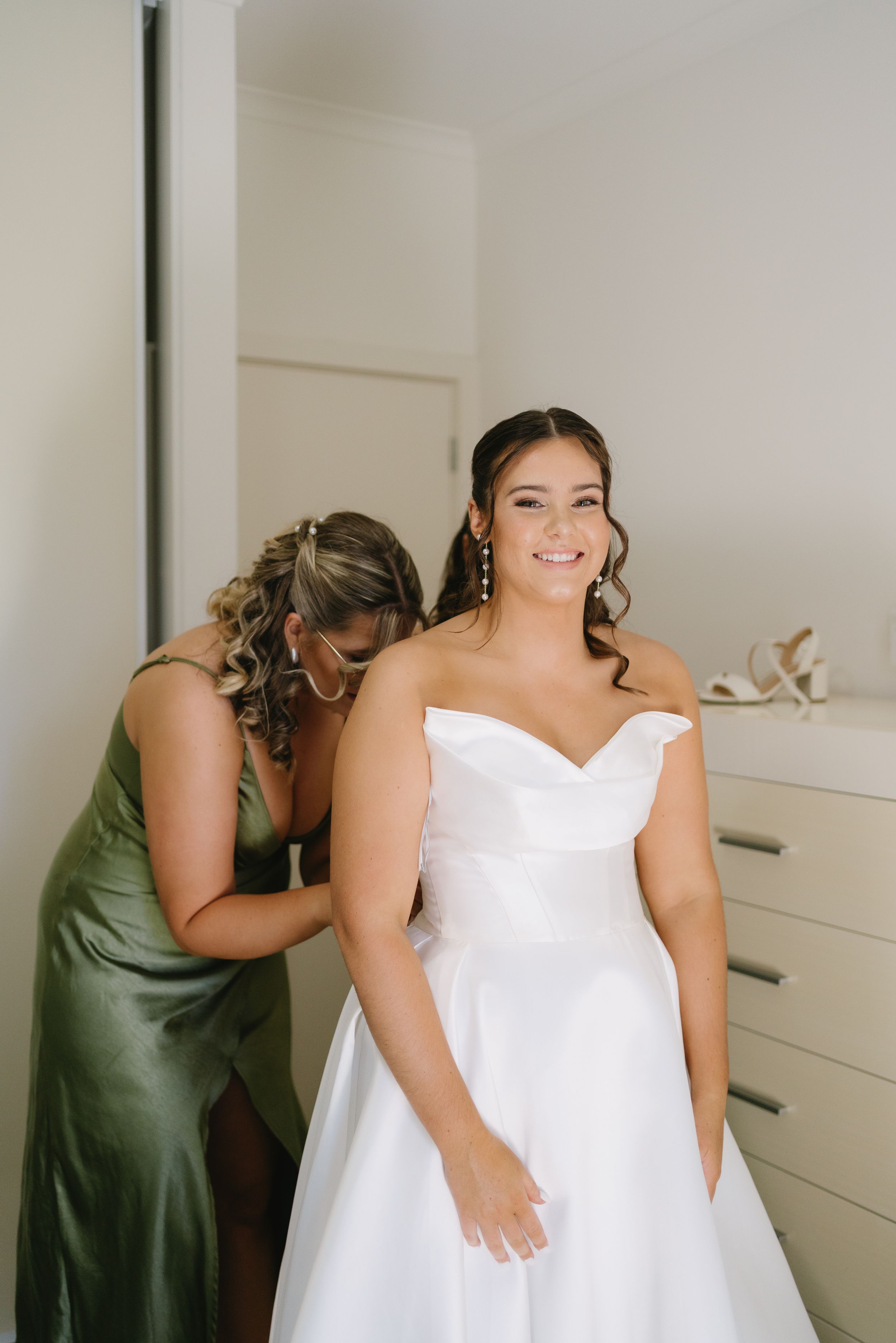 Getting ready moments in a bright room as wedding preparations take place.