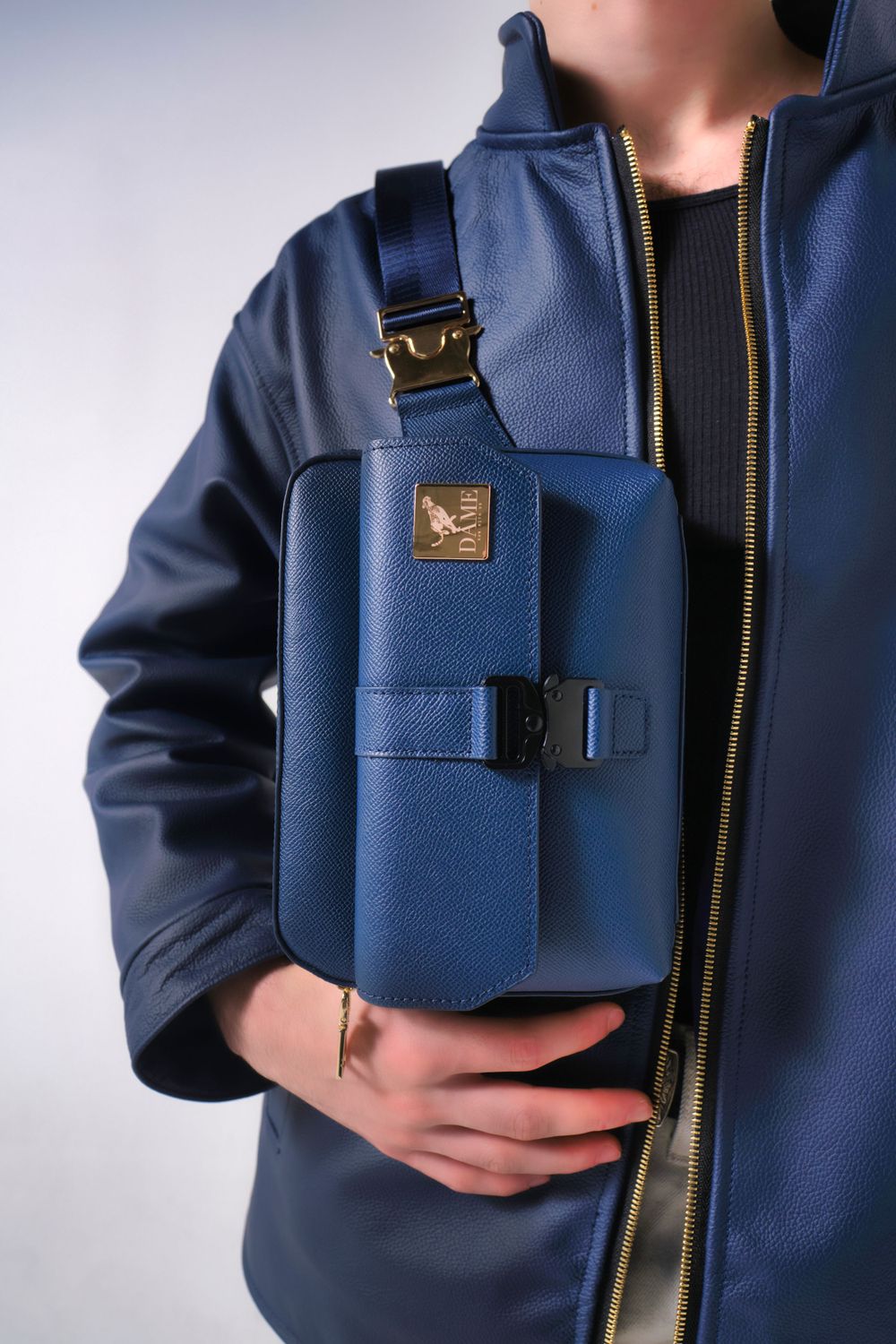 Close-up of navy blue tactical chest bag with metal hardware details.