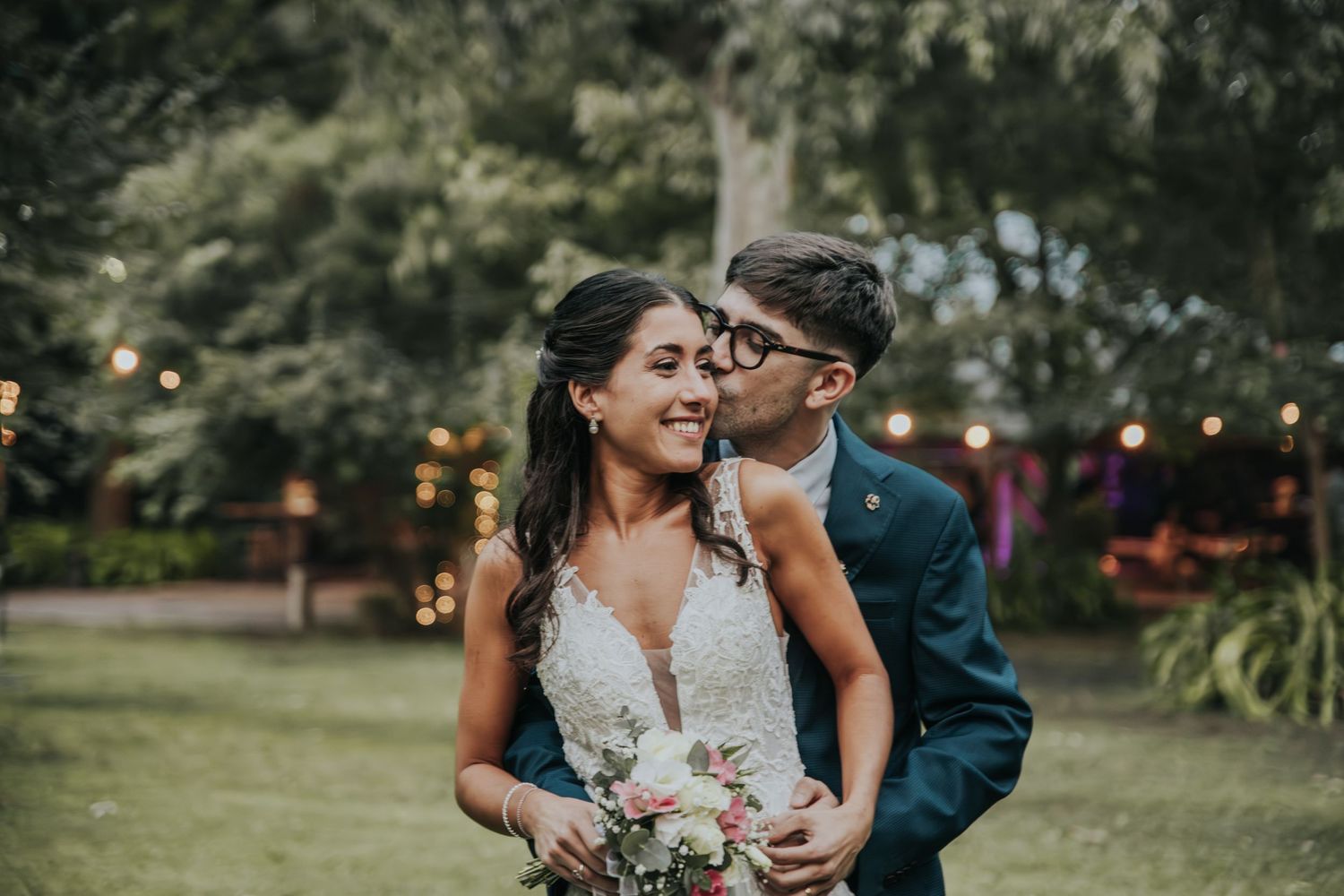 Recién casados dándose un beso para un fotoiman en su boda