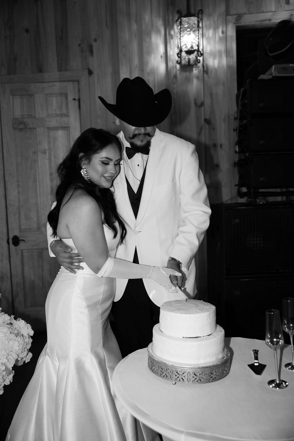 A sequence of black and white photos showing a couple cutting their elegant wedding cake together.