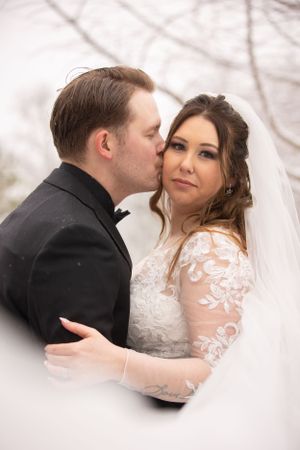 Intimate wedding portrait captured during a tender moment in winter.