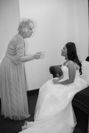 A tender moment shared during wedding preparations in a simple white room.