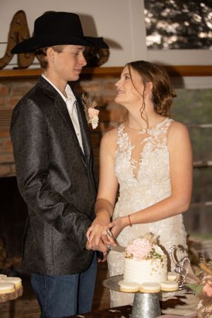 Intimate moment between newlyweds next to their wedding cake at the reception.