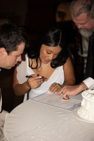 Wedding ceremony paperwork being signed at a reception table.
