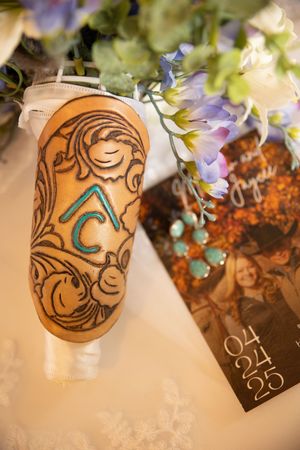 Decorated prosthetic leg with ornate swirls and turquoise details displayed with flowers and a card.