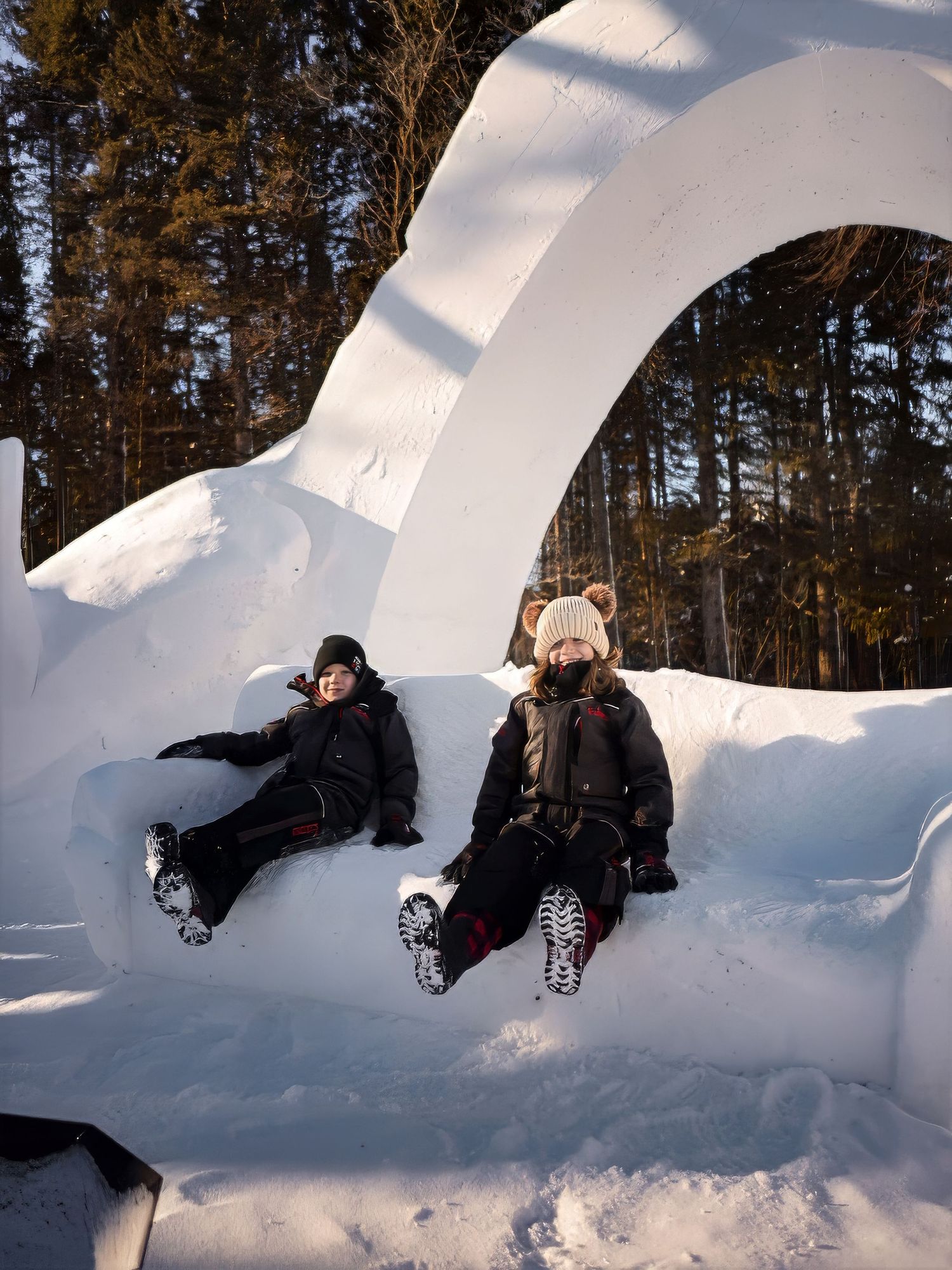 People playing in giant snow sculpture during winter activities.