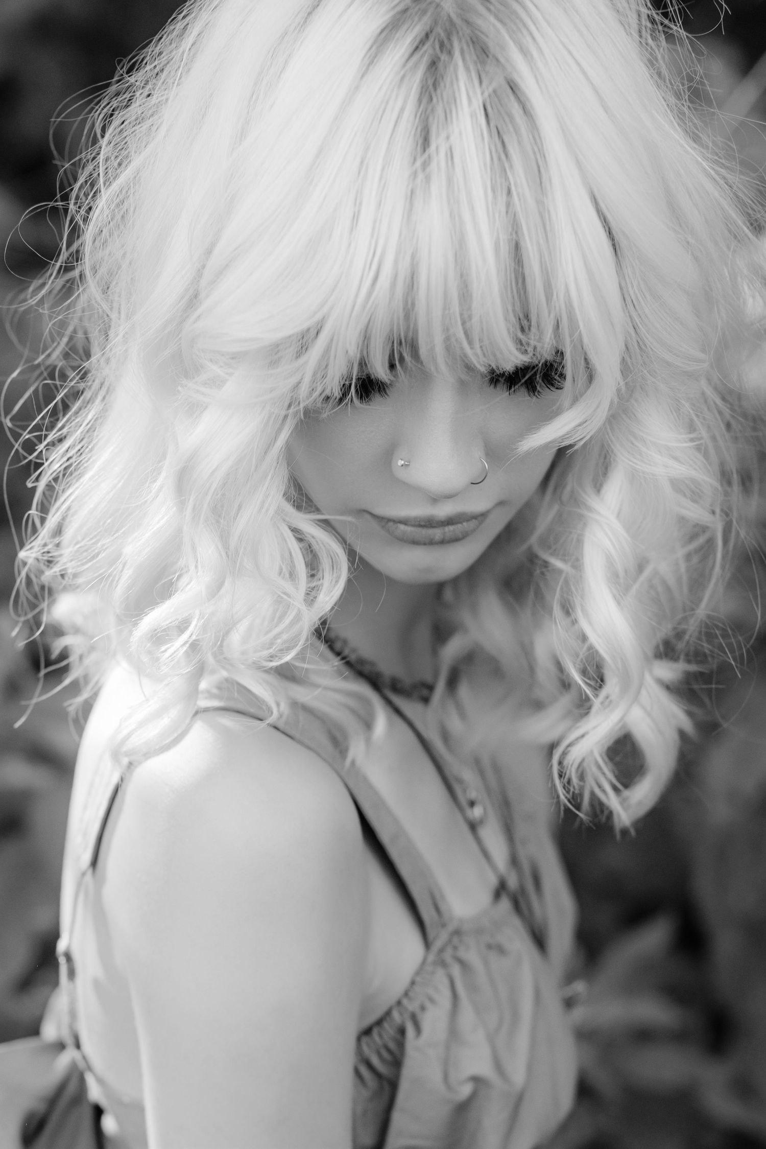 Close-up black and white portrait showing blonde wavy hair and soft expression.