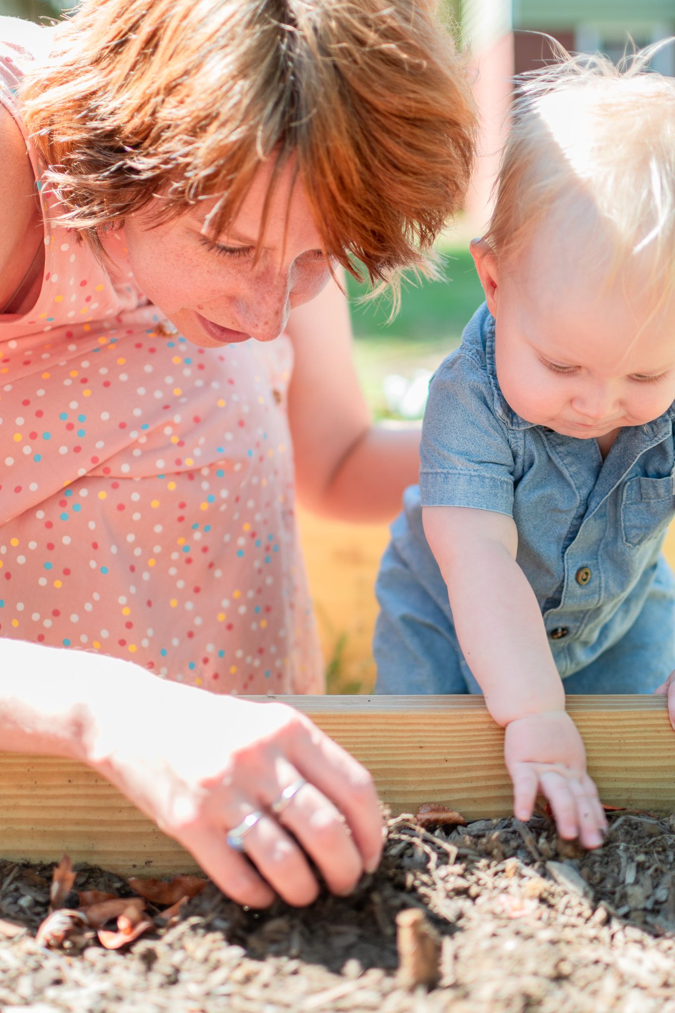 Mom and baby play in the garden during their at-home family session in Winston-Salem.