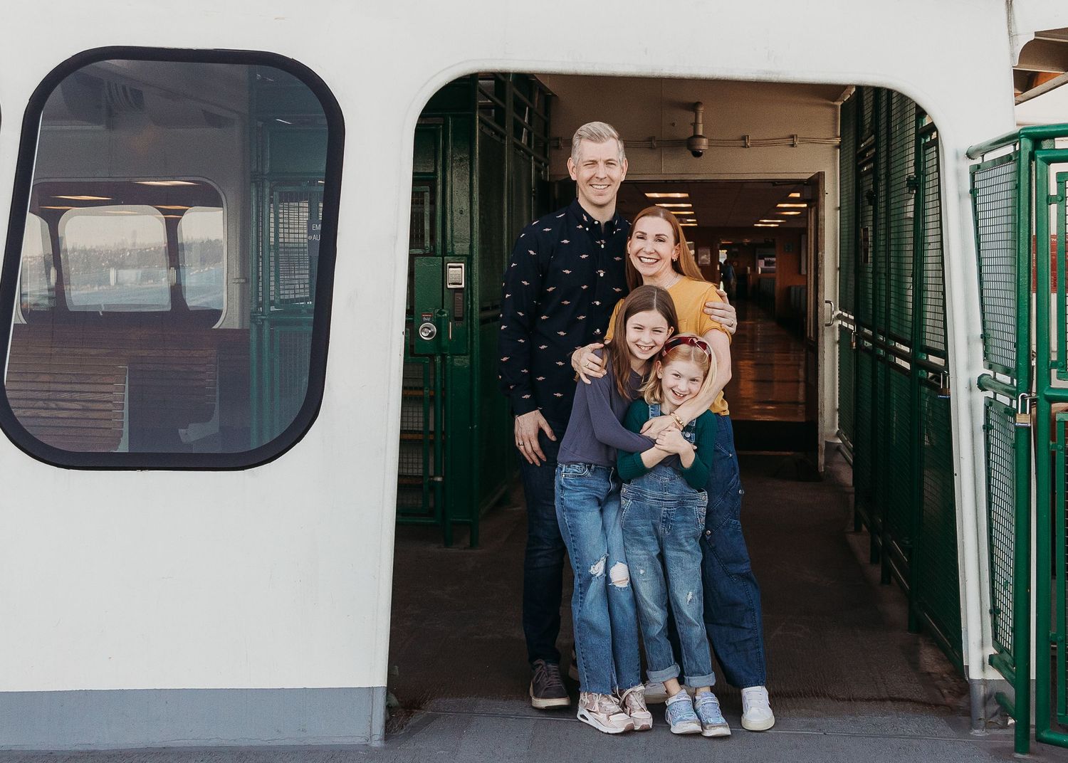 Family standing together in the doorway of a ferry or train car entrance.