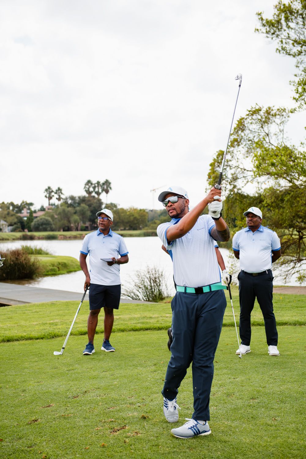 Corporate photography services by Rynali, an image of a golf day participant, three men on the golf course, teeing off.