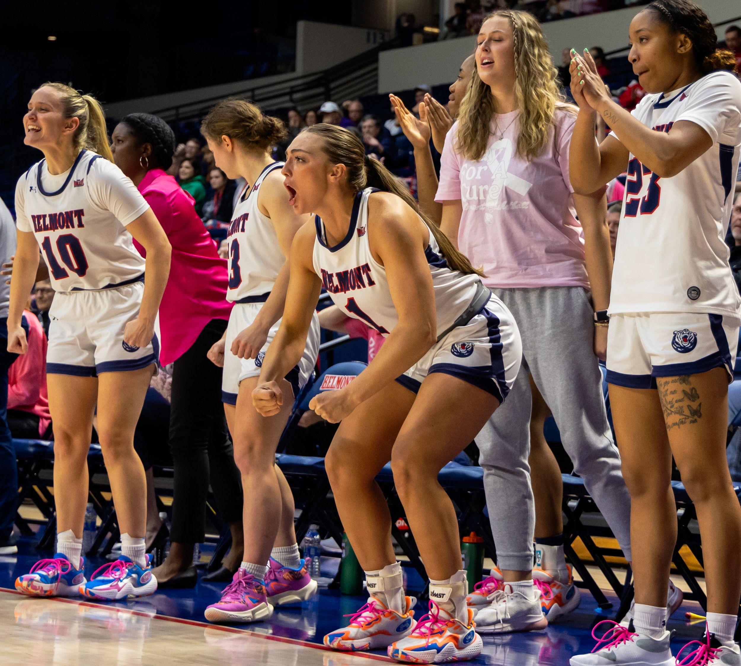 Belmont women's basketball team celebrates enthusiastically on the sideline bench during a home game.