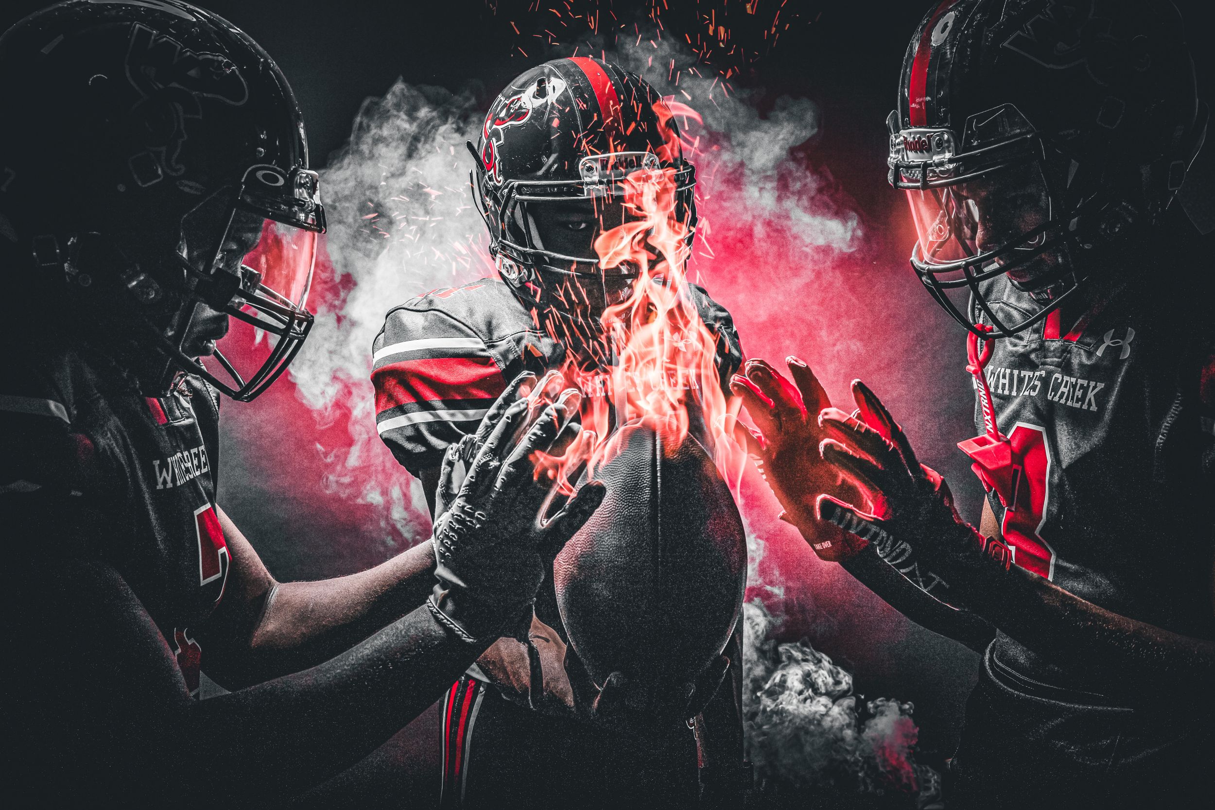 Dramatic composite of three football players with glowing ball surrounded by red smoke and fire.