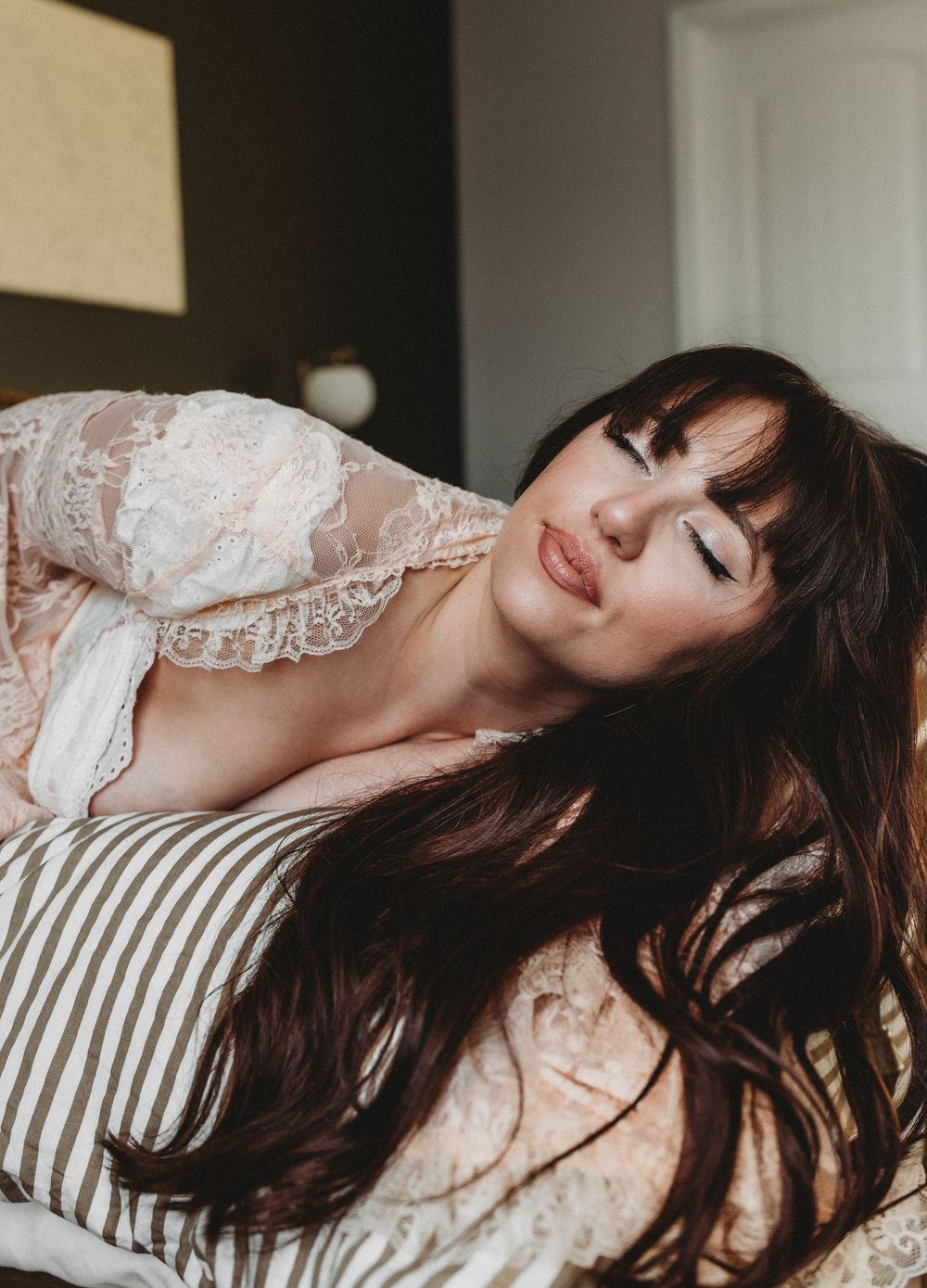 A series of artistic photos showing a person with dark hair reclining on a striped pillow in dreamy poses.