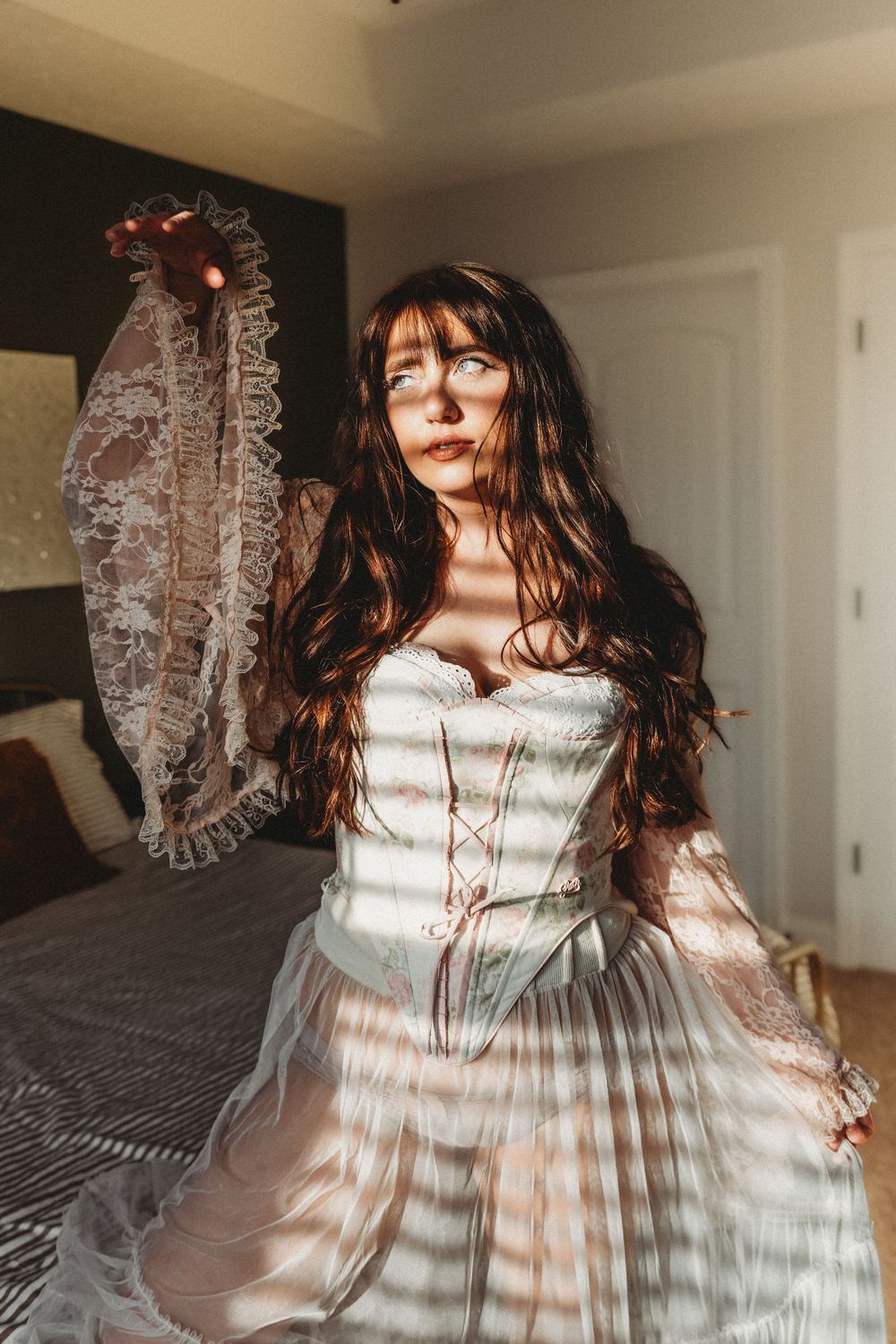 A vintage-inspired white lace dress with ruffled details is captured in a dreamy sunlit indoor photoshoot sequence.