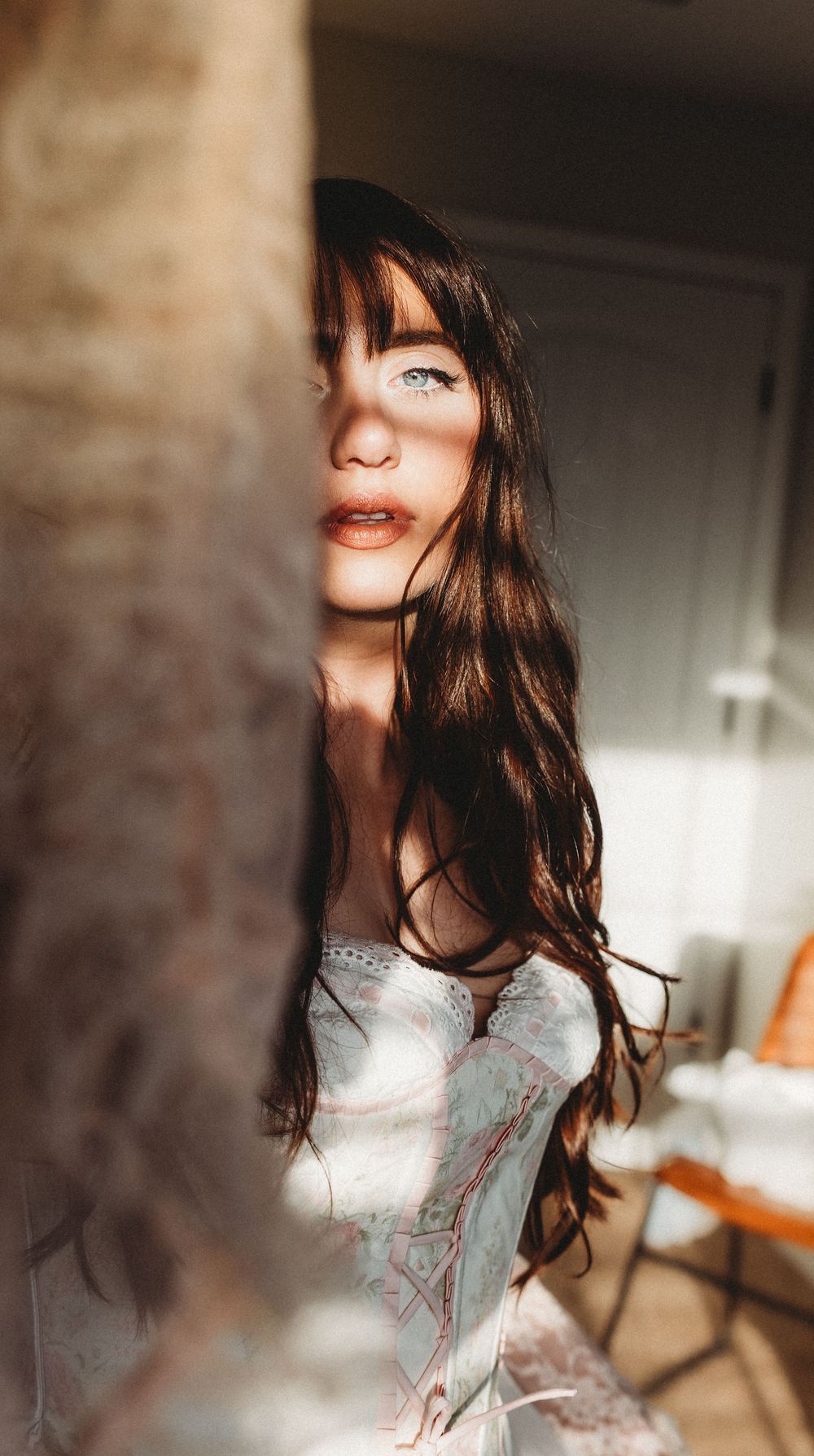 A series of artistic portrait shots showing dark flowing hair and a white lace top in moody lighting.
