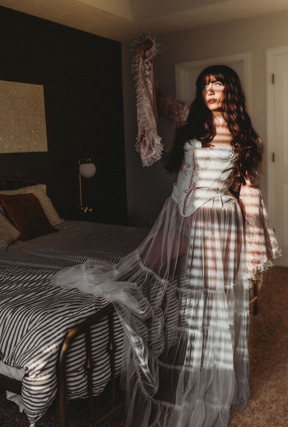 A series of long exposure photos showing ethereal movement in a striped dress against a dark interior setting.