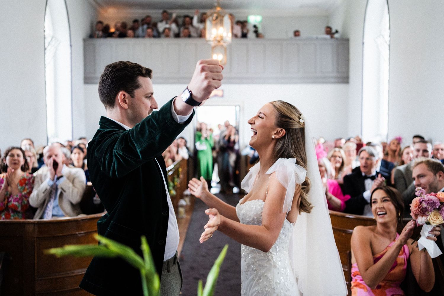 Wedding guests dance and celebrate together on a lively dance floor at a reception party.