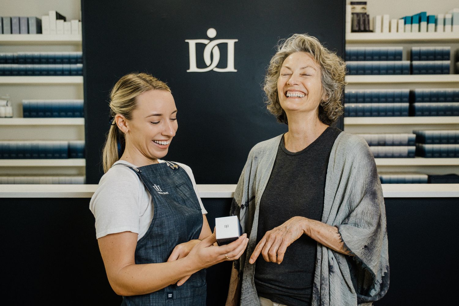 Two people share a joyful moment while sitting together in an office environment.