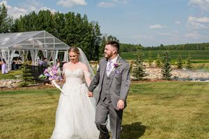 Outdoor wedding venue with rolling hills and green landscape in the background.