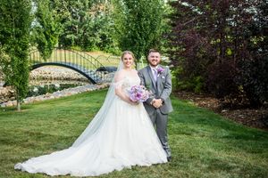 Elegant outdoor wedding ceremony setup with lush greenery and garden landscaping.