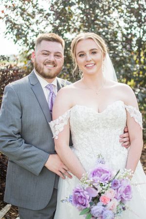 Wedding portraits showing tender moments between newlyweds with a beautiful purple and pink floral bouquet.