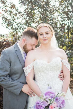 Tender wedding moments captured in a series of romantic poses between newlyweds with purple floral bouquet.
