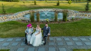 Panoramic view of wedding venue with stone wall and manicured lawn.