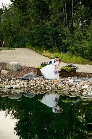 Series of rock-lined pools with crystal clear water reflecting trees and natural landscaping along the edges.