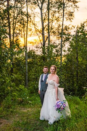 Sunset wedding photography session among trees with golden light filtering through the foliage.