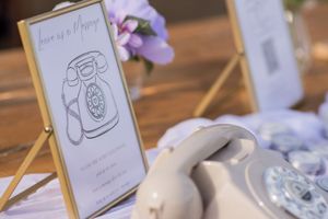 Wedding table decorations with purple accents and illustrated menu cards.